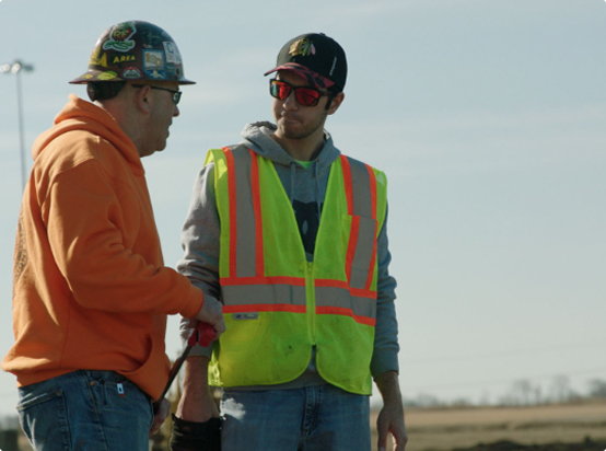 Two Local 150 Engineer Operators discussing on a construction site