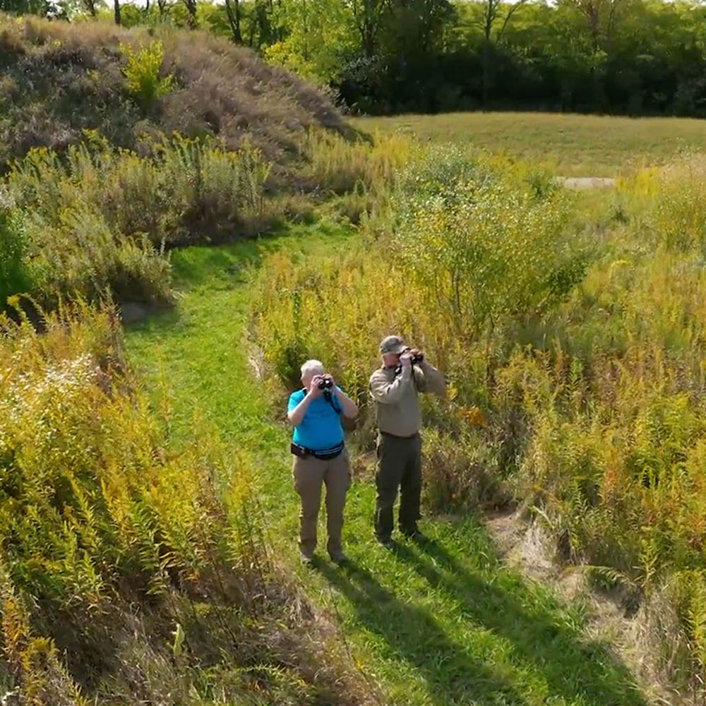 Two men search for birds it the Midewin National Tallgrass Prairie outside of Joliet, IL