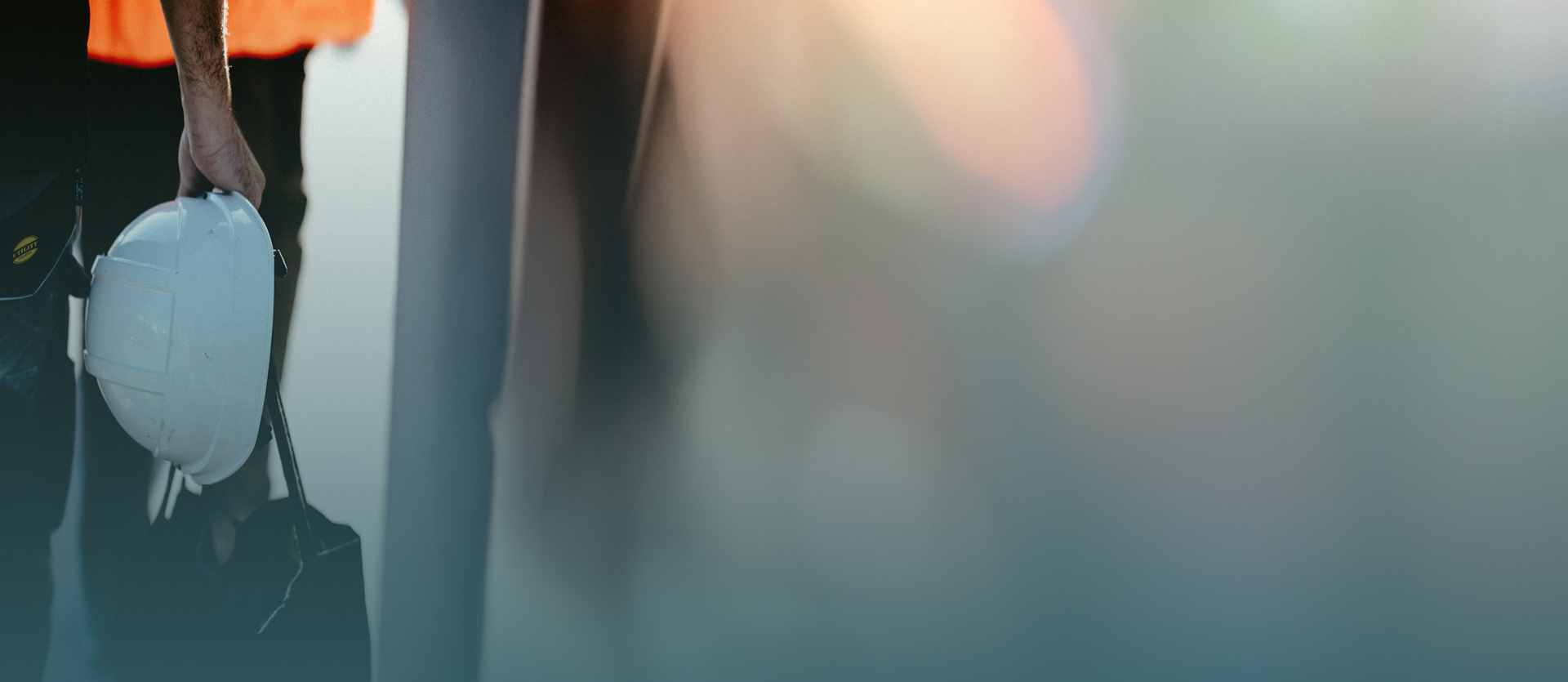 An artistic photo of a person holding a hard hat