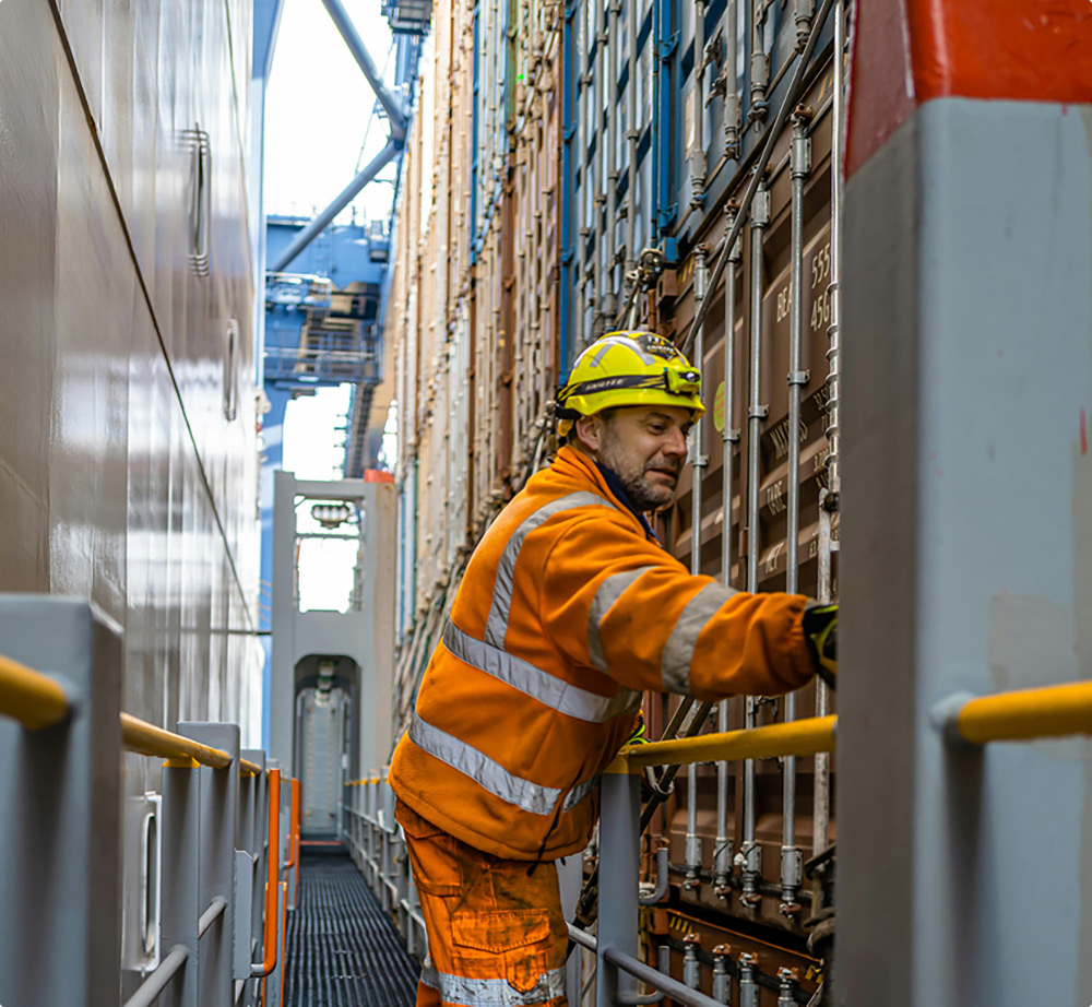 A rail yard worker securing shipping containers at CenterPoint Intermodal Center in Joliet, IL